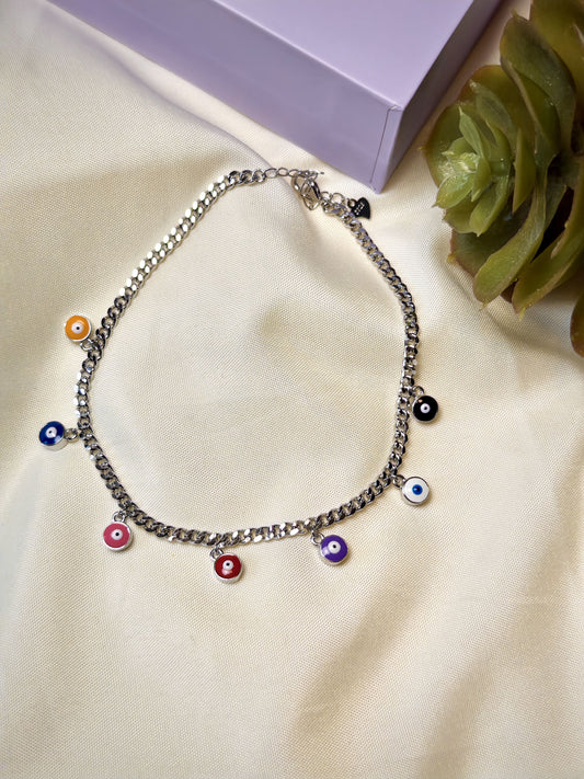 Anklet with colorful evil eye charms on a beige surface