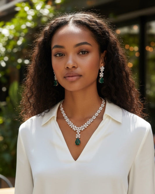 Woman wearing a white blouse and green jewelry set outdoors