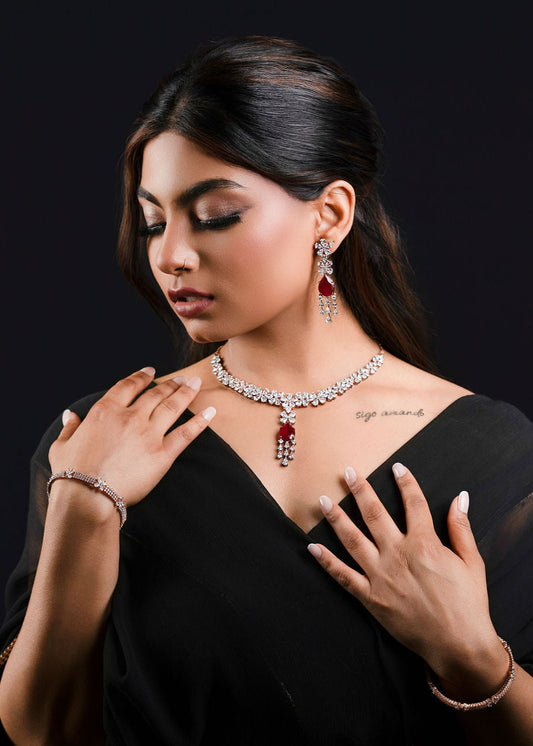 Woman wearing a black saree with kundan bridal jewelry on a dark background