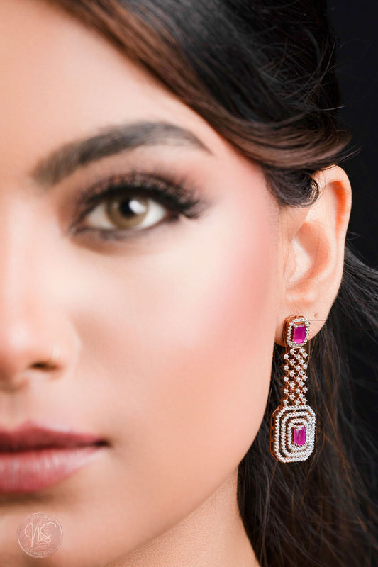 Close-up of a woman wearing a pair of earrings with a dark background
