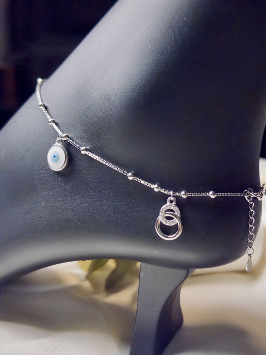 Silver anklet with charms on a mannequin foot