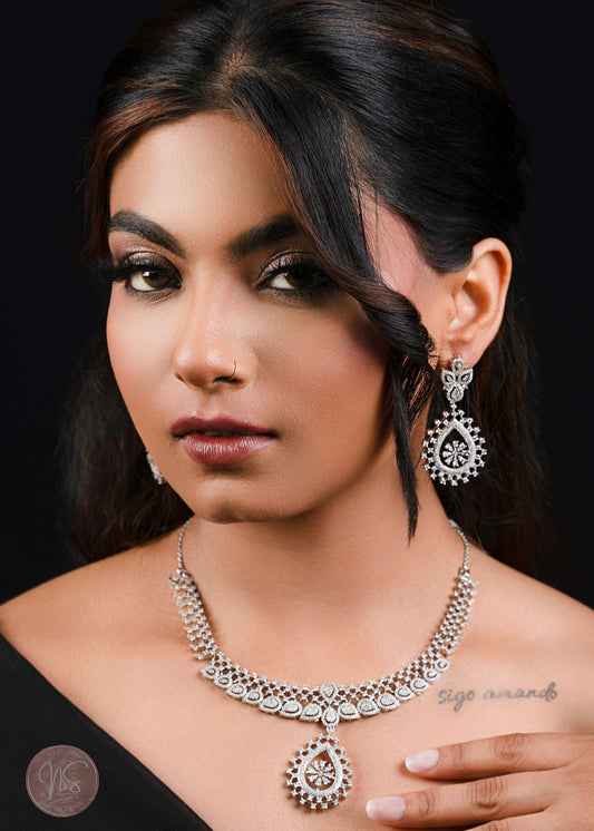 Woman wearing silver jewelry against a black background