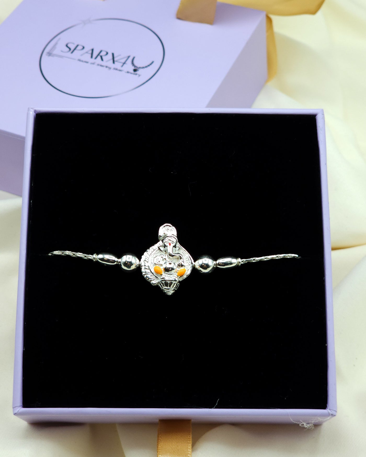 Silver bracelet with a Ganesha charm in a black box.