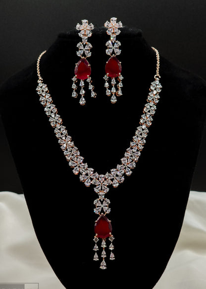 Kundan Bridal Jewelry set with necklace and earrings featuring red stones on a black stand.