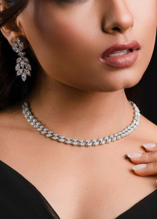 Woman wearing a black dress with jewelry on a dark background