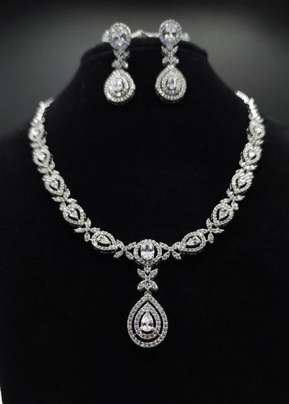 Silver necklace and earrings set on a black stand with 'SPARX4U' branding.