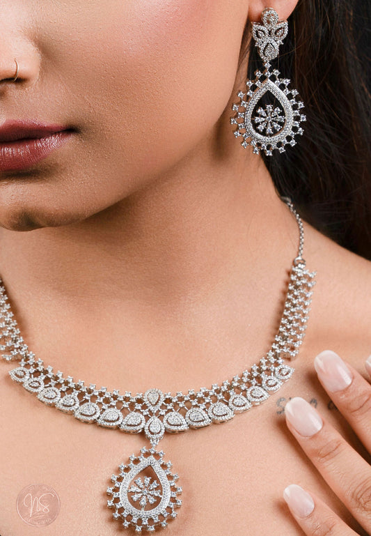 Silver necklace and earrings on a model with a close-up view