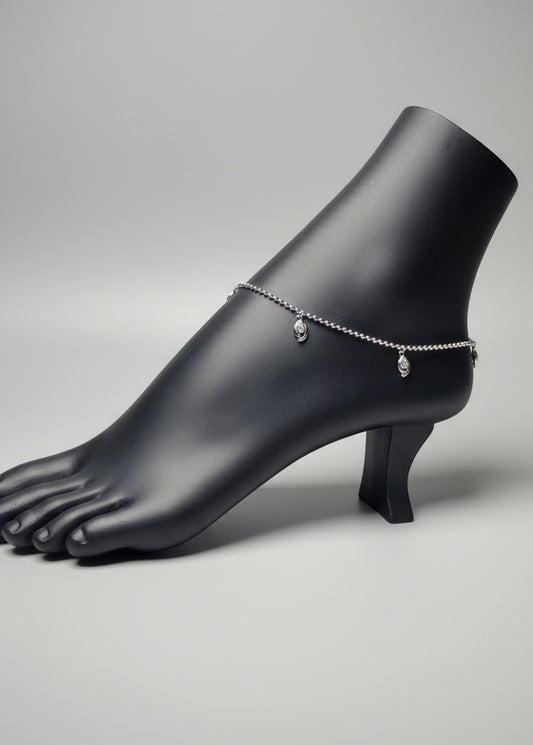 Silver anklet on a mannequin foot with a blurred background