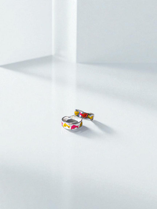 Two colorful toe rings on a white surface with a soft shadow